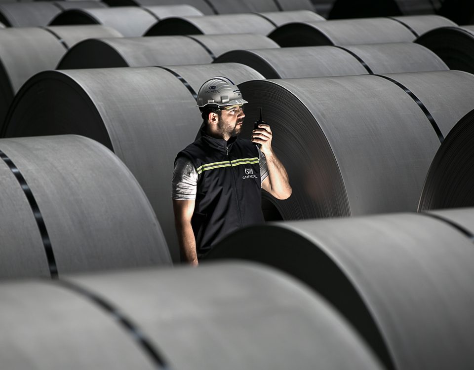 Gazi Metal employee inspecting steel coils in a modern industrial metal production facility.